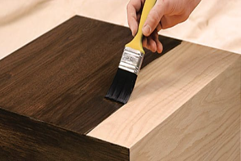 paintbrush staining wooden furniture